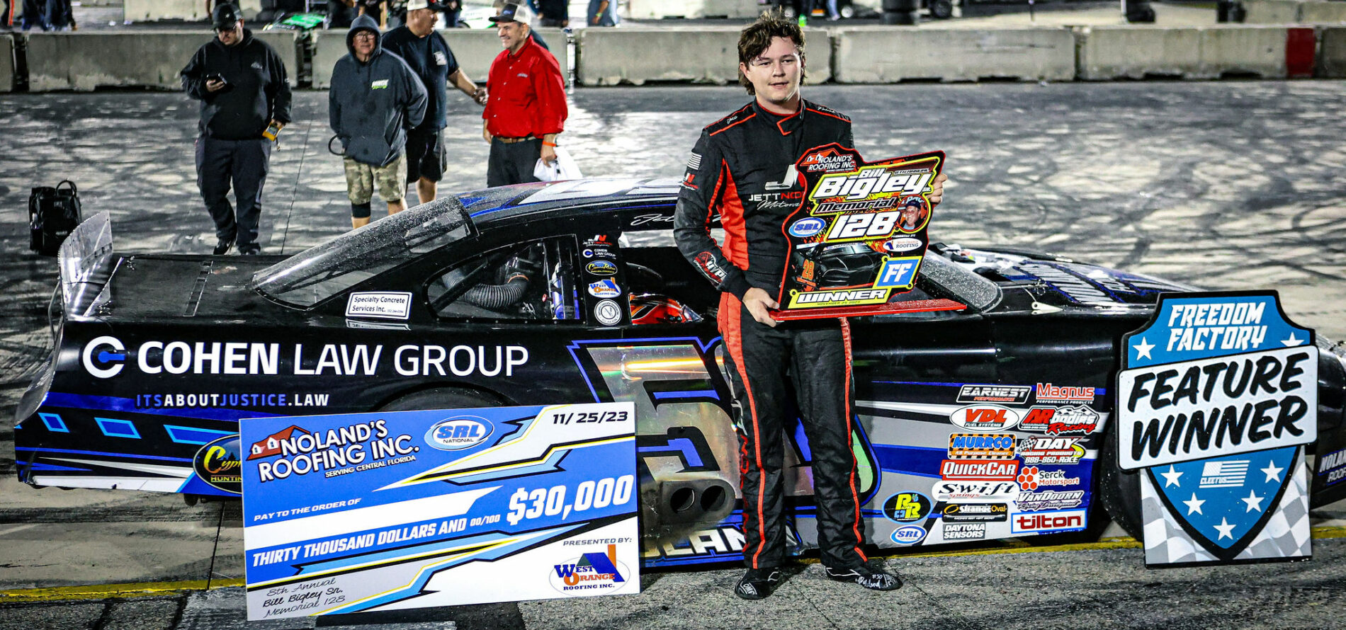 image of Jett Noland in front of Jett Noland Motorsports car number 50 holding the victory sign for the 8th annual Bill Bigley memorial race