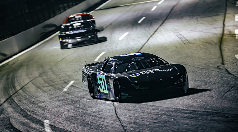 Night race at Cordele Motor Speedway featuring Jett Noland Motorsports – The #50 car from Jett Noland Motorsports leads the pack, speeding around the track at Cordele Motor Speedway. The thrilling race under the lights highlights the competitive spirit of motorsport racing